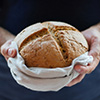 Two hands holding a loaf of bread