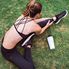 Woman stretching her leg on the grass