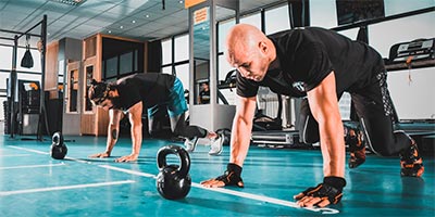 Two men doing push-ups in a workout area