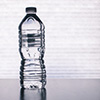 A bottle of water against a white wall