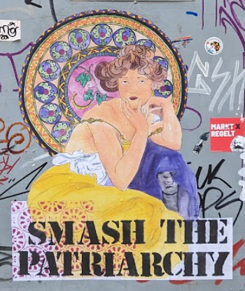 A graffiti mural of a woman in front of stained glass with the words 'SMASH THE PATRIARCHY
