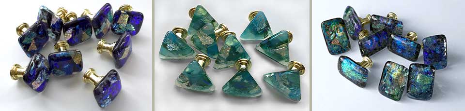 image trio of multiple glass knobs, left cobalt blue squares with brass hardware; middle teal triangles with gold hardware; right multi colored blue rectangles with gold hardware.