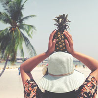 women holds pineapple, beach, palm tree, enzyme