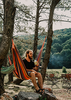Hammocking with man drinking lemonade in nature