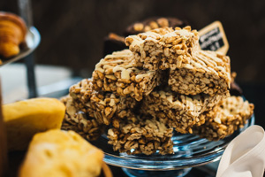 A glass pedstal with a stack of our housemade vanilla granola bars on top.