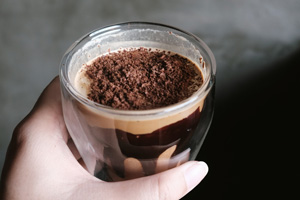 A caffe mocha with cocoa powder and chocolate sauce down the side.