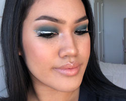 Glitter liner and teal eyeshadow with nude lip gloss makeup look.