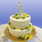 A cake and flowers with a small statue of two people kissing. Click here to go to the wedding cake section.