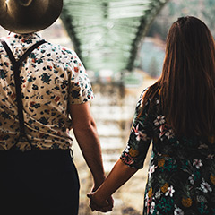 anniversary shoot couple holding hands under bridge