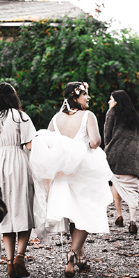 bridesmaid holding bride dress