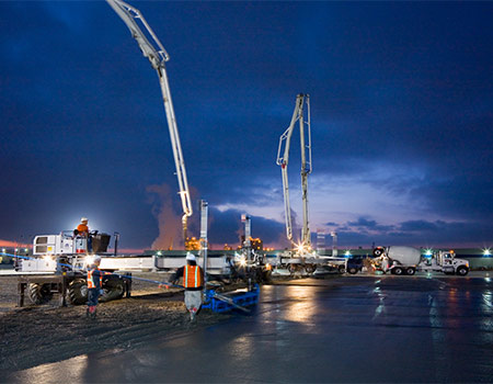 A pour crew pouring multiple sections of a concrete slab for the Air Force at Travis Air Force Base. The crew is working through the night to complete the job.