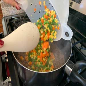 Picture of the veggies and meat getting mixed together.