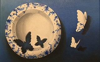 Two cutouts of butterflys fly out of a decorative plate, and two butterfly shaped holes are left behind
