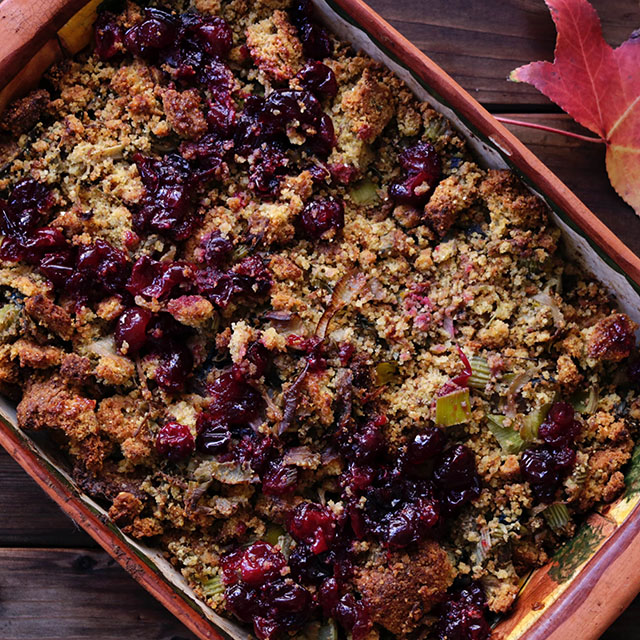 A baked casserole with cranberries on top of it.