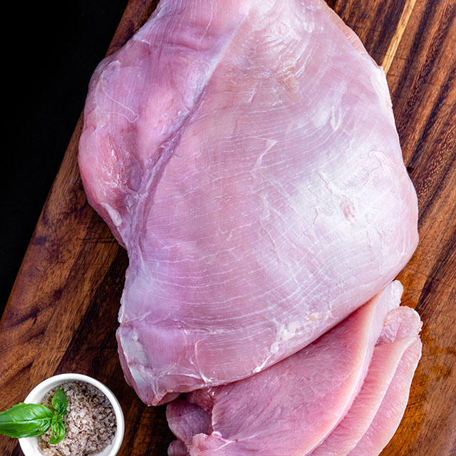 Raw turkey on a wooden cutting board.