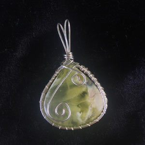 Murky green cabochon pendant wrapped in silver wire.