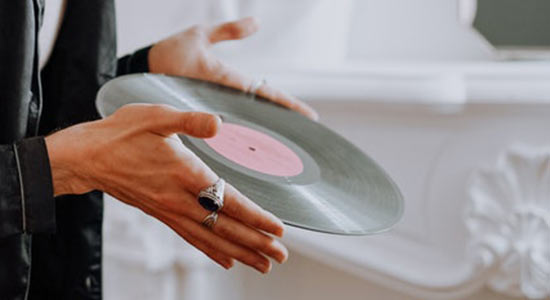 a picture of a man holding an LP 33-rpm record with his hands