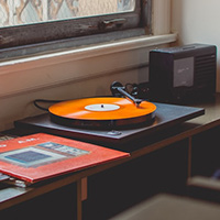 a picture of an orange record on a turntable next to a window