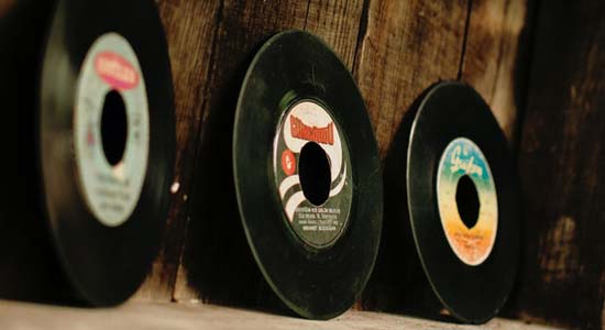 a picture of various 45-rpm records on a wooden stand in a workshop