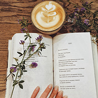 person reading poetry book with a cup of coffee
