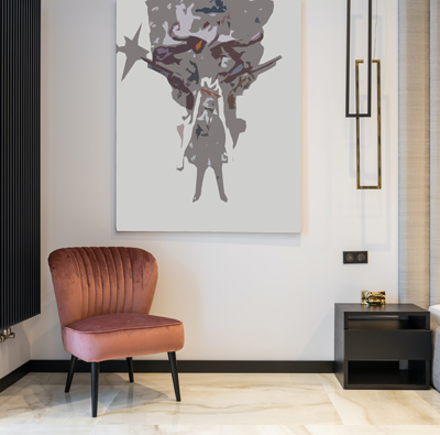 A velvet chair with a painting above it