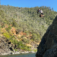Me jumping off of a high rock while into the water while pointing at the camera
