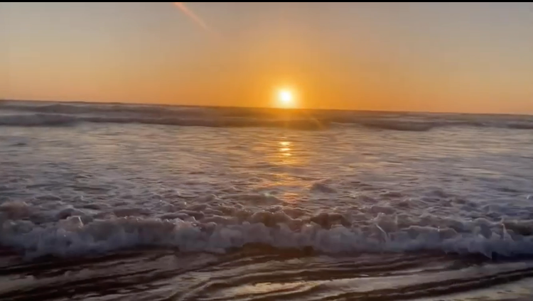 orange sunset with ocean waves close by