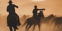 two cowboys with horses herding