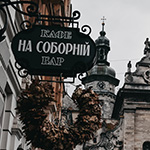 The hanging sign of a cafe-bar with the cathedral on the background