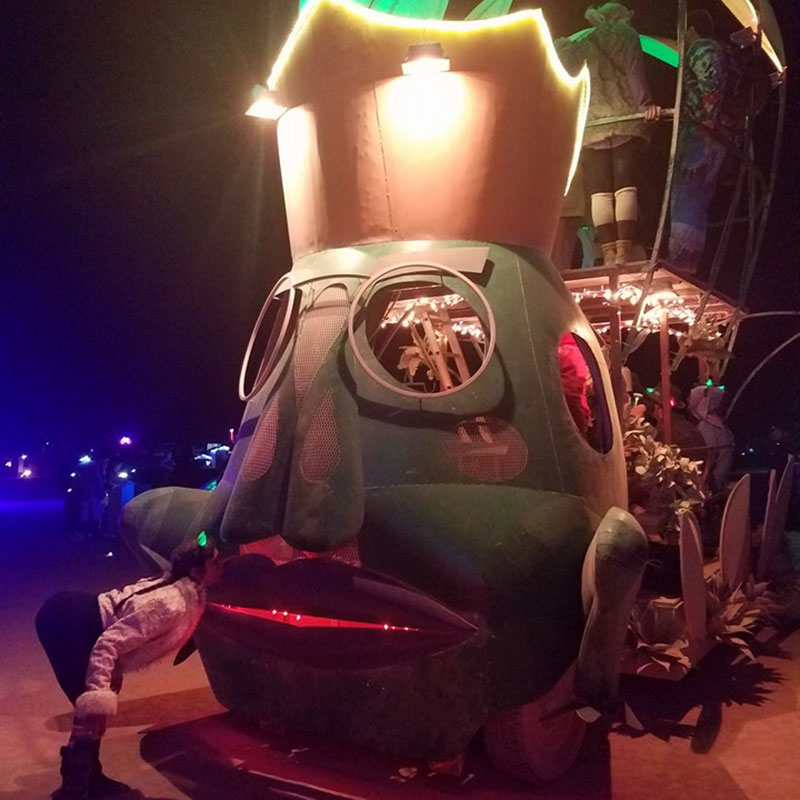 The frog prince art car close up as a girl kisses the front of the frog prince
