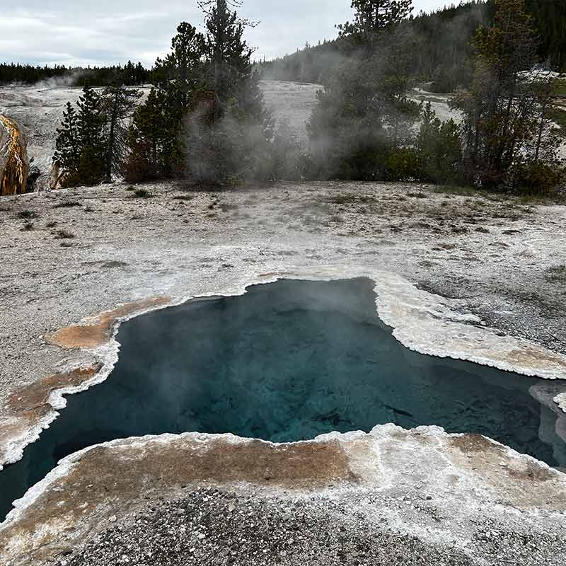 A dark blue steaming pool amongst white ground steaming