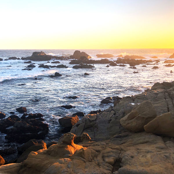 A sunset over a rocky ocean side