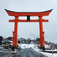 A large red Torii gate in the winter