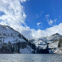 Calm Eagle Lake with snow covered mountains beyond its shores