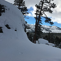 Snow covered rock with view of mountains in the background