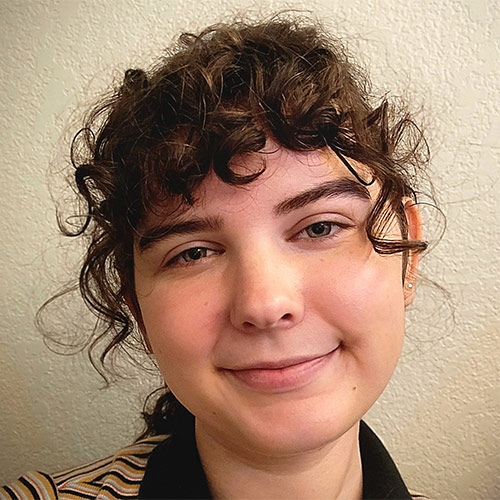 A picture of a girl smiling at the camera with a white background.