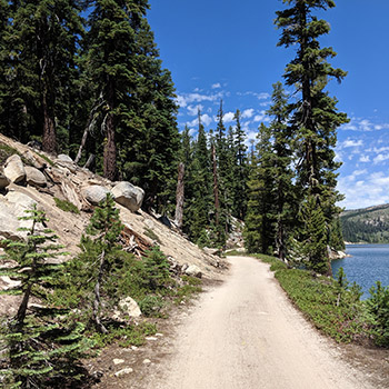 dirt trail by mountainous lake