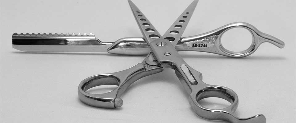 Black and white picture of haitcutting scissors and razor.