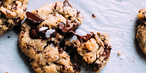 A warm chocolate chip cookie revealing the chocolate inside