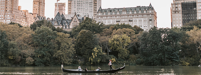 People taking a gondola ride on the lake in Central Park