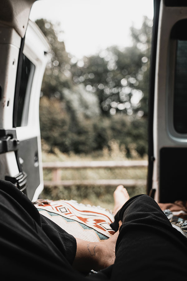 person laying in back of van with open door