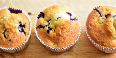 Three blueberry muffins sitting in a row.