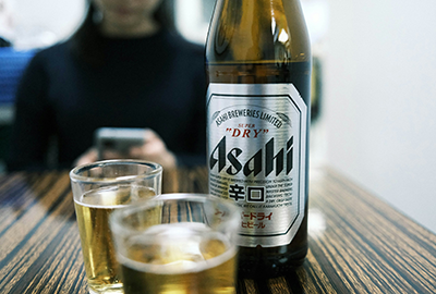 Cold glass of Asahi beer with a bottle beside it
