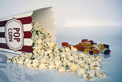 Popcorn and gummy bears spilling from a box