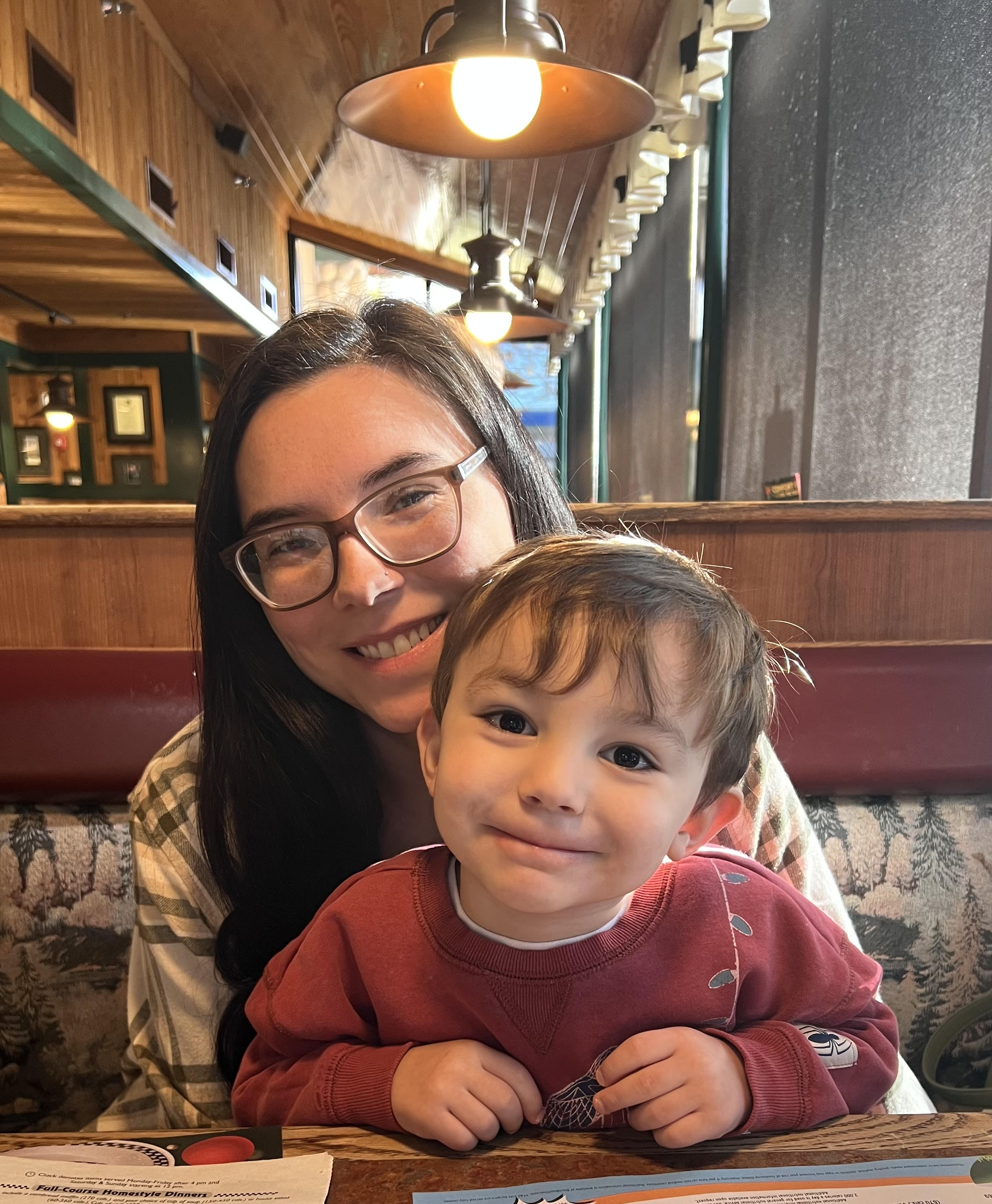 A mother holding her young son in a restaurant.