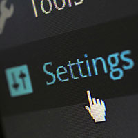 A close-up photo of a computer screen showing the settings button with a cursor hovering over it 