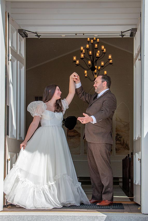 Photo of a married couple dancing in the doorway of a church