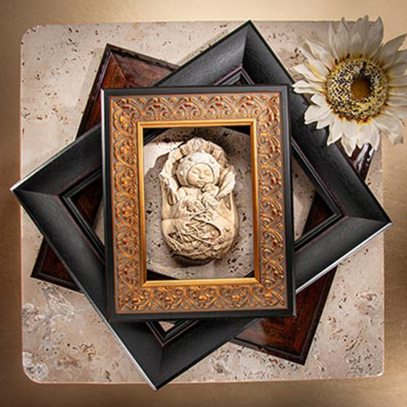 Still photograph of a baby figurine surrounded by 3 frames