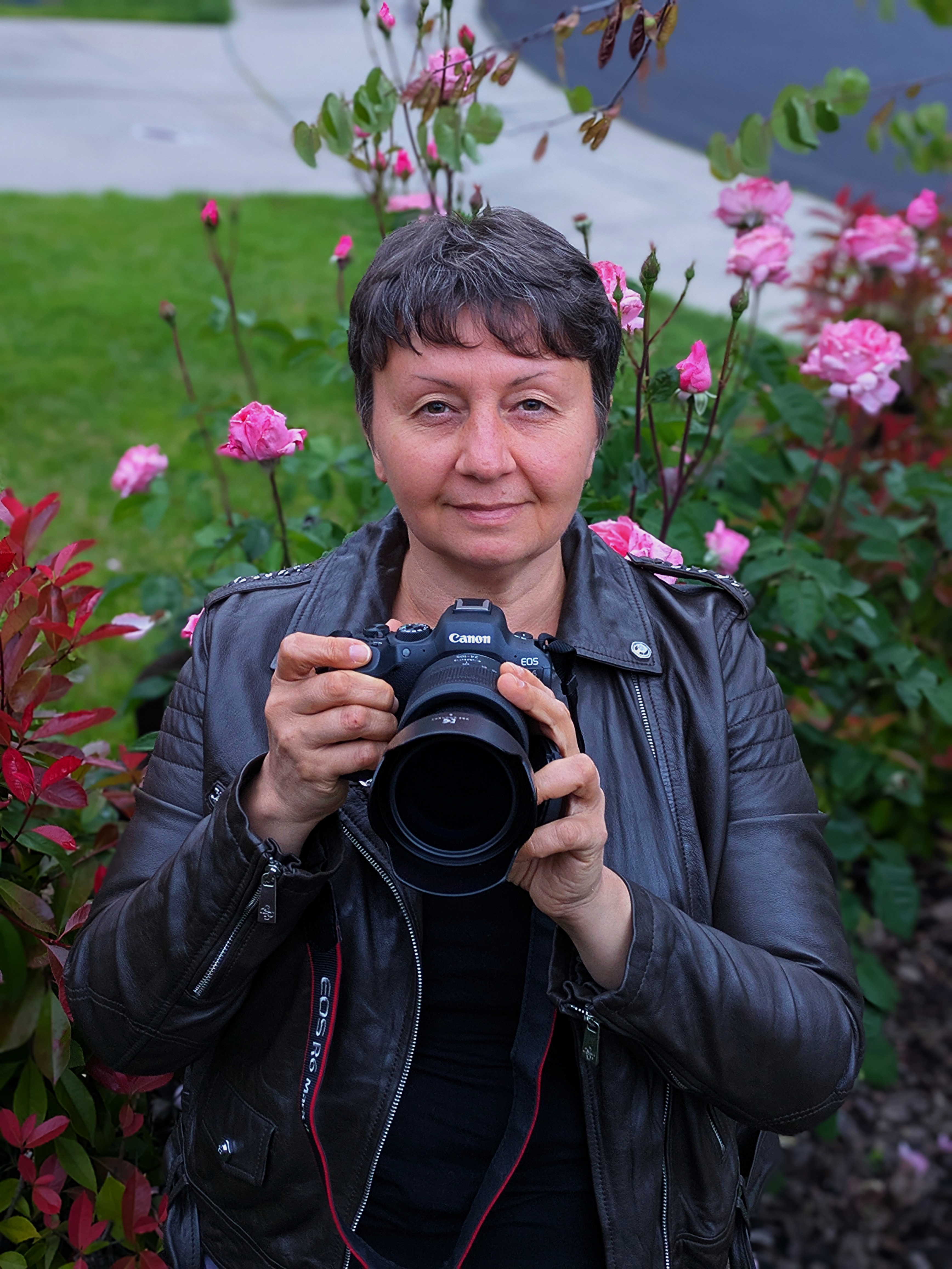 Selfie of me holding my camera with roses on a backround