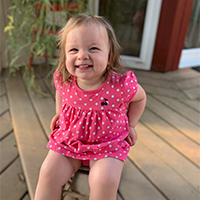 Image of female toddler child smiling sitting in a chair
